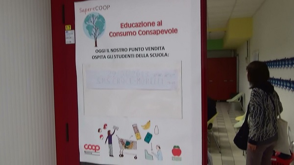 <p>店舗内のNovacoopの消費者教育が実施される店舗内教室 教室の入口には、「今日は学校の生徒たちが授業に来ています」と書いた貼紙</p>